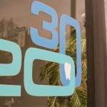 A close-up of a glass door or window featuring large 20 and 30 graphic lettering in light blue.